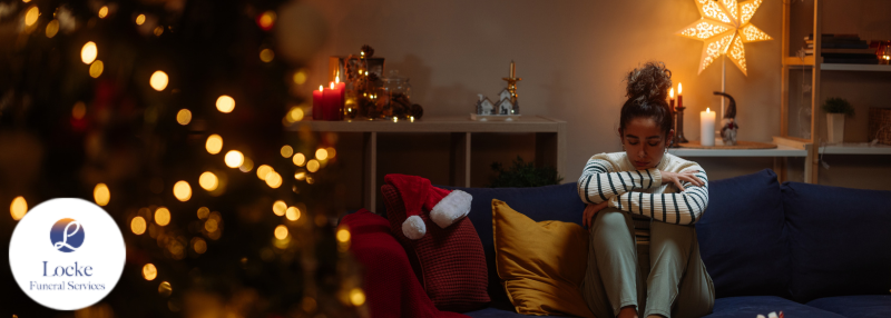 Woman sitting on couch alone with house decorated for holidays