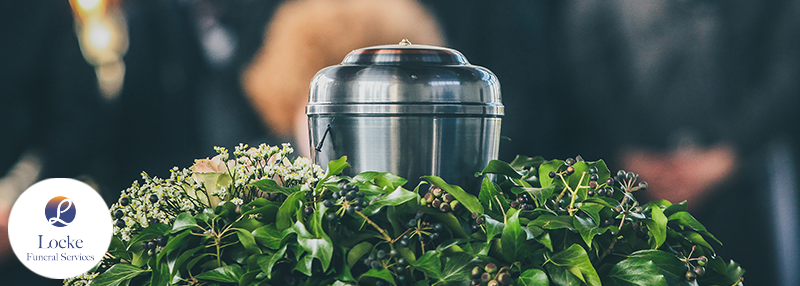 Image of cremation urn on bed of greenery.