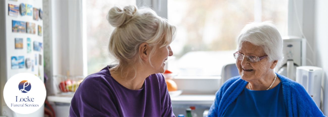 Image shows an older and younger woman talking in their home